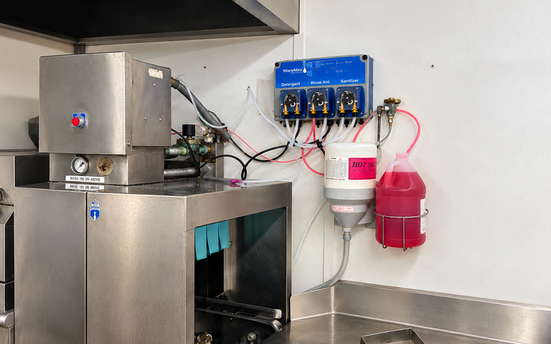 Wall-mounted automatic chemical dispensing unit